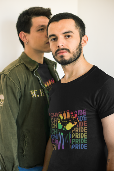 A gay male couple facing each other, with the guy on the right looking into the camera while wearing a Richmond Pride t-shirt.