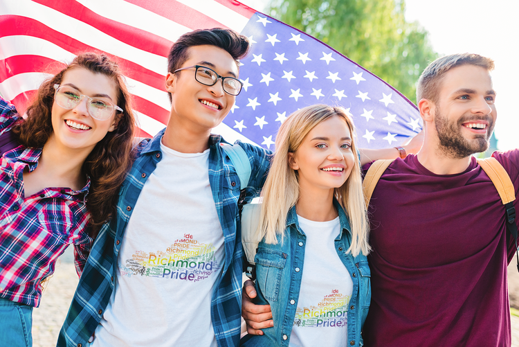 A group of friends, two male and two female, in front of an American flag while wearing Richmond Pride t-shirts.