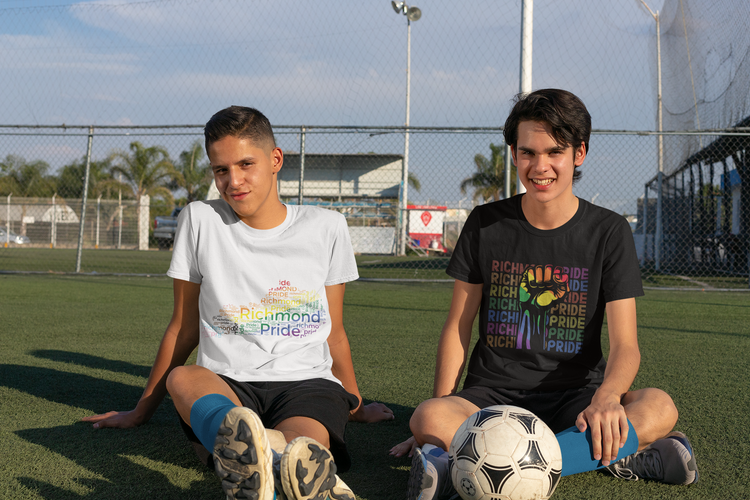 Teenage boys wearing Richmond Pride merchandise while resting from a game of soccer.