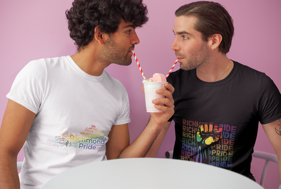 A gay male couple drinking a milkshake using separate straws from the same cup while wearing Richmond Pride t-shirts.